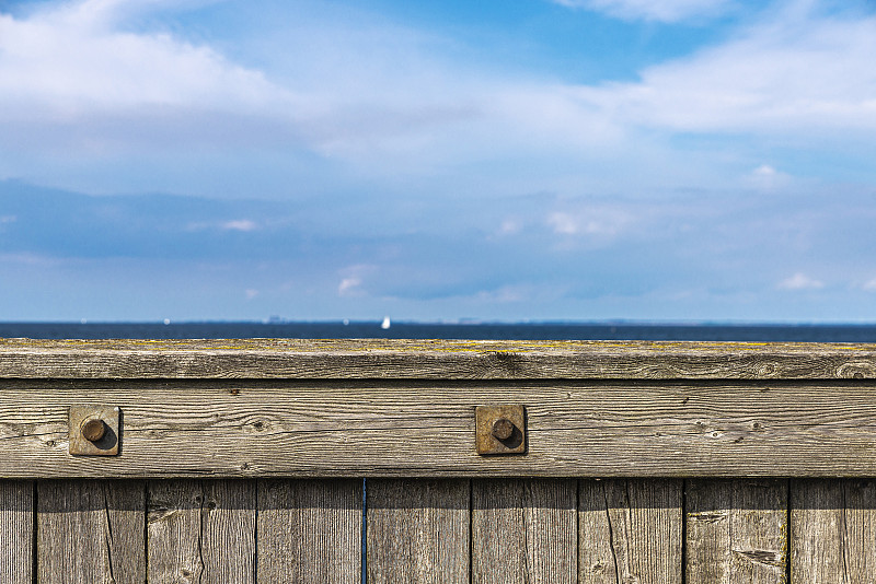 Wooden,railing,on,a,dike,in,front,of,the,Baltic,Sea,as,background,in,V?stra,Hamnen,,Malmo,,Sweden
