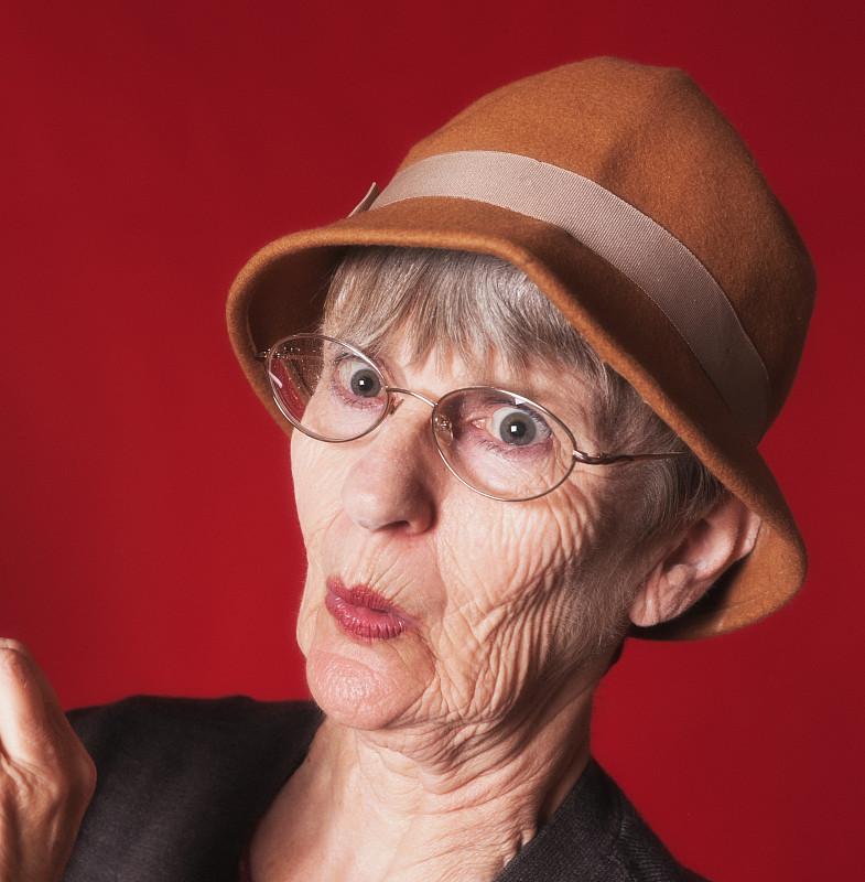 帽子,注视镜头,老年女人,嘴唇,愉快的,肖像,红色背景,仅一个老年女人,撅嘴,影棚拍摄