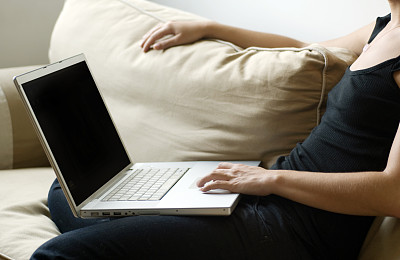 女人坐在沙发上，用笔记本电脑，中段