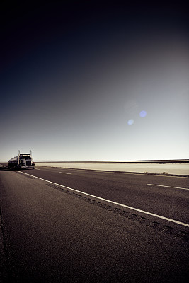 在平坦公路上孤独的半卡车和拖车