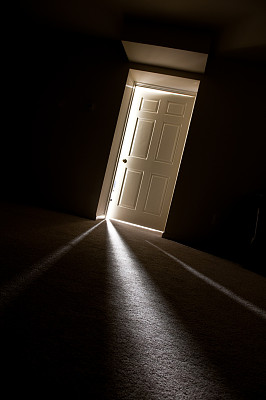 光线透过门缝照射的黑暗走廊