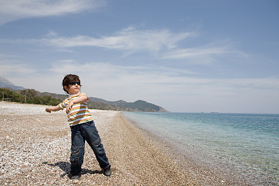 男孩往海里扔石头