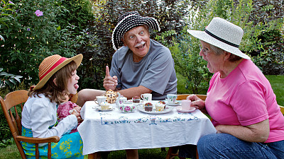 爷爷奶奶和漂亮的孙女在茶会上玩得很开心