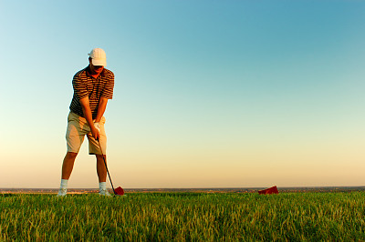 日落时分，一个人在打高尔夫球