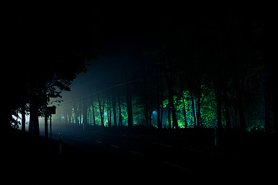 夜间行驶在乡村道路上的汽车的前灯