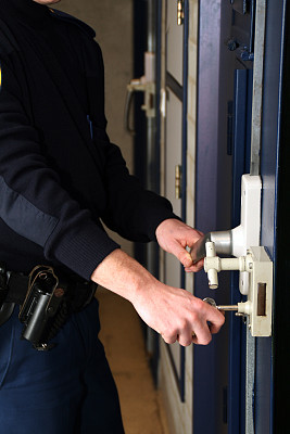 一个狱警正在锁牢房的门