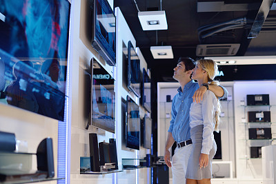 年轻夫妇在消费电子商店买电视