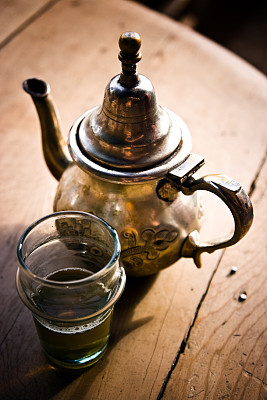一杯北非绿茶与壶，木材背景