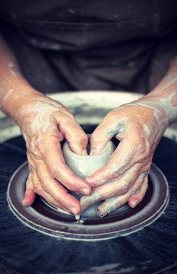 两只手在陶工轮上塑造粘土
