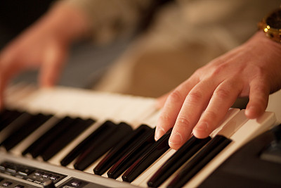 男人的手放在钢琴键盘上