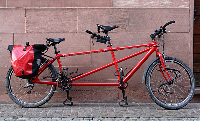 红色的双人自行车靠在墙上