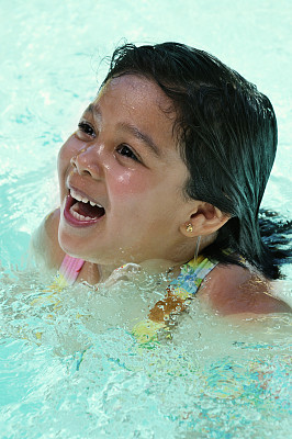 小女孩在游泳池的水里微笑