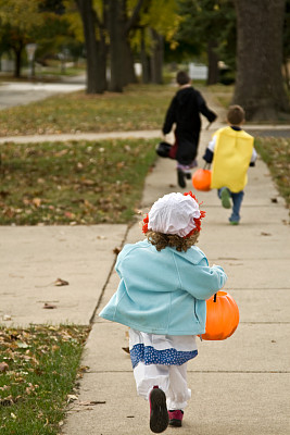 孩子们穿着戏服在街上玩不给糖就捣蛋