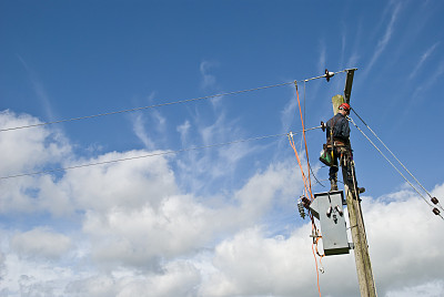 公用事业工人在蓝天下修理电线