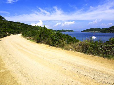 洛克瓦湾周围的道路，蓝色的海水和一艘船可见