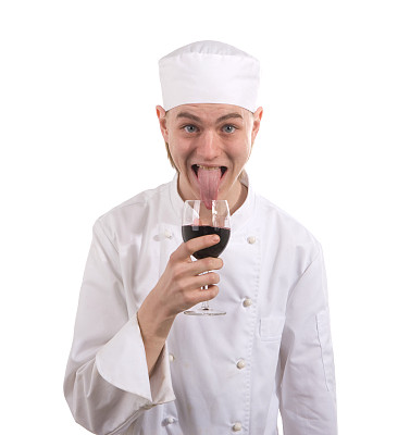 年轻厨师用舌头品尝红酒