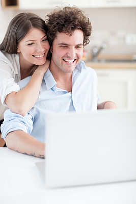 微笑的情侣带着笔记本电脑