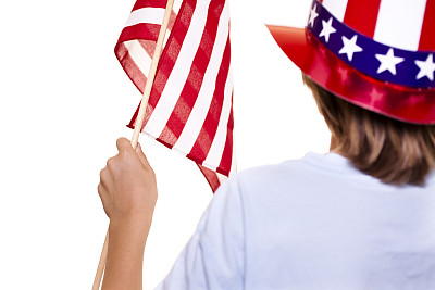 小男孩戴着爱国帽，举着国旗。