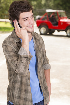 科技:随便的男人和朋友在电话里聊天。吉普车的背景。