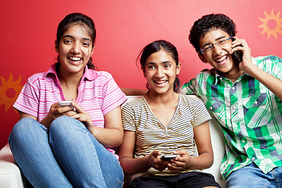 一群兴高采烈的印度青少年在电话中交谈