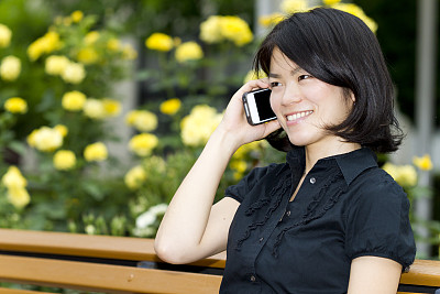 年轻的日本女子愉快地用手机交谈