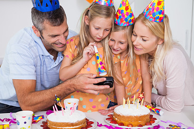家人在生日聚会上看数码相机