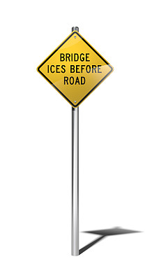 在道路警告标志(美国)前，桥上结冰，道路弯曲