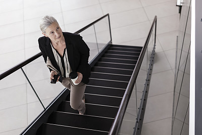 高级女商人走进她的办公大楼 高级女商人走进她的办公大楼