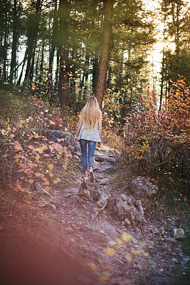 秋天里走在森林小径上的年轻女子