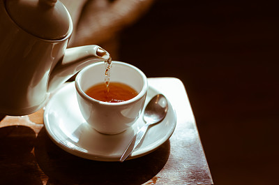 茶杯放在茶托上，倒着茶，