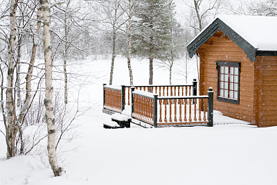 典型的挪威小屋，有白桦树和雪