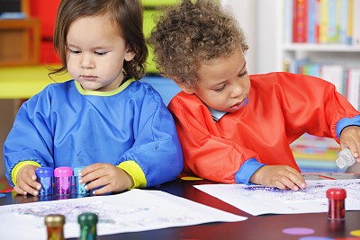 两个小男孩在画画时用胶水和闪光粉