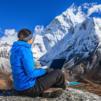 在尼泊尔珠穆朗玛峰国家公园，一名妇女正在使用笔记本电脑