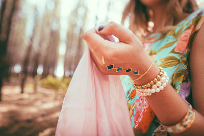 女人的手上装饰着珠宝和一个临时纹身