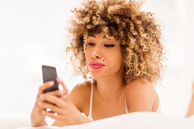 年轻的非洲裔美国妇女用手机发短信。