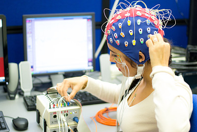 实验室里用脑电图和EEG电极的女人
