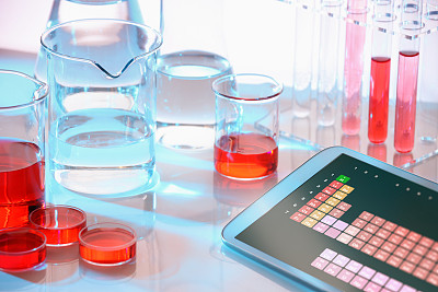 现代科学实验室，玻璃化学设备，显示元素周期表的平板