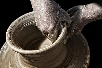 陶工泥泞的双手制作陶土