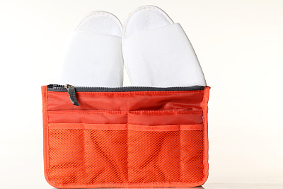 橙色洗漱包，包括一双白色拖鞋