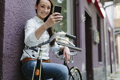 一名女子在城市街道上使用智能手机