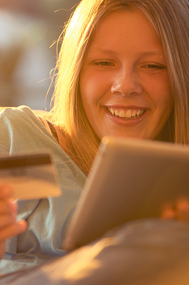 用平板电脑和信用卡购物的女人