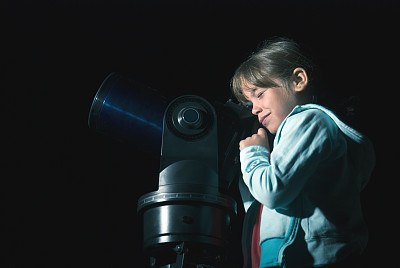 孩子在夜里用望远镜看东西
