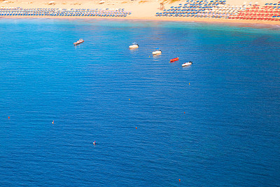 小船，海滩和宁静的蓝色海浪