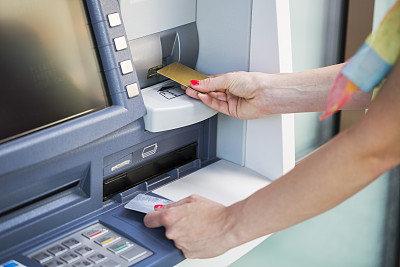 一个女人用信用卡从ATM机里取钱