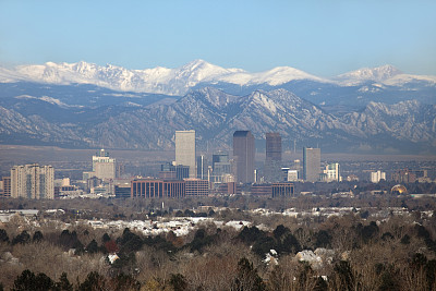 多雪的落基山脉和科罗拉多州丹佛市中心的摩天大楼社区