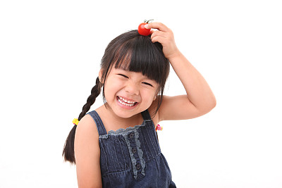 快乐的女孩玩着新鲜的樱桃番茄