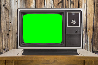 老电视与色度键绿色屏幕和木墙