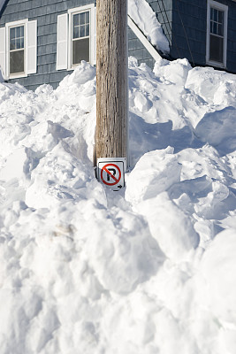 “禁止停车”的牌子被埋在雪堆里。