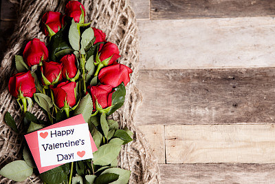 情人节快乐。红玫瑰花束，便签，粗麻布。乡村表。