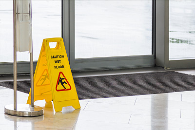 黄色警告:背景上的地板湿滑标志。